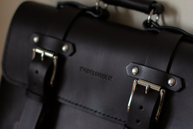 close up black leather satchel with stainless steel silver