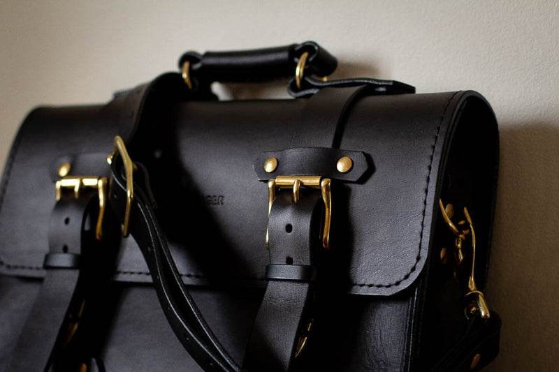 close up black leather and solid brass satchel