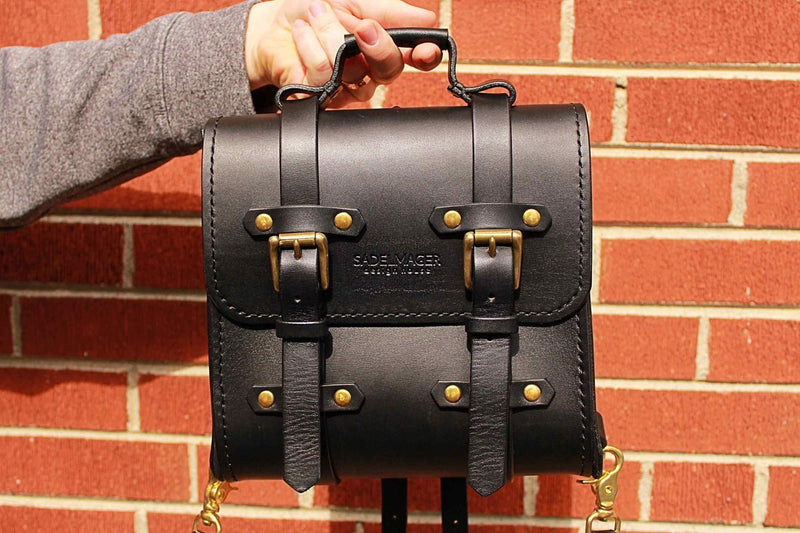 black Sadelmager campus messenger with brass buckles held up