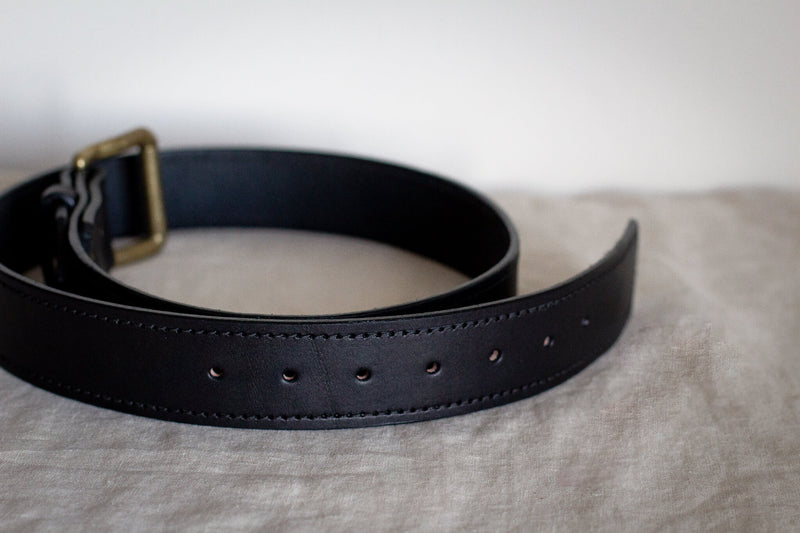stitching close up on black leather saddle maker belt
