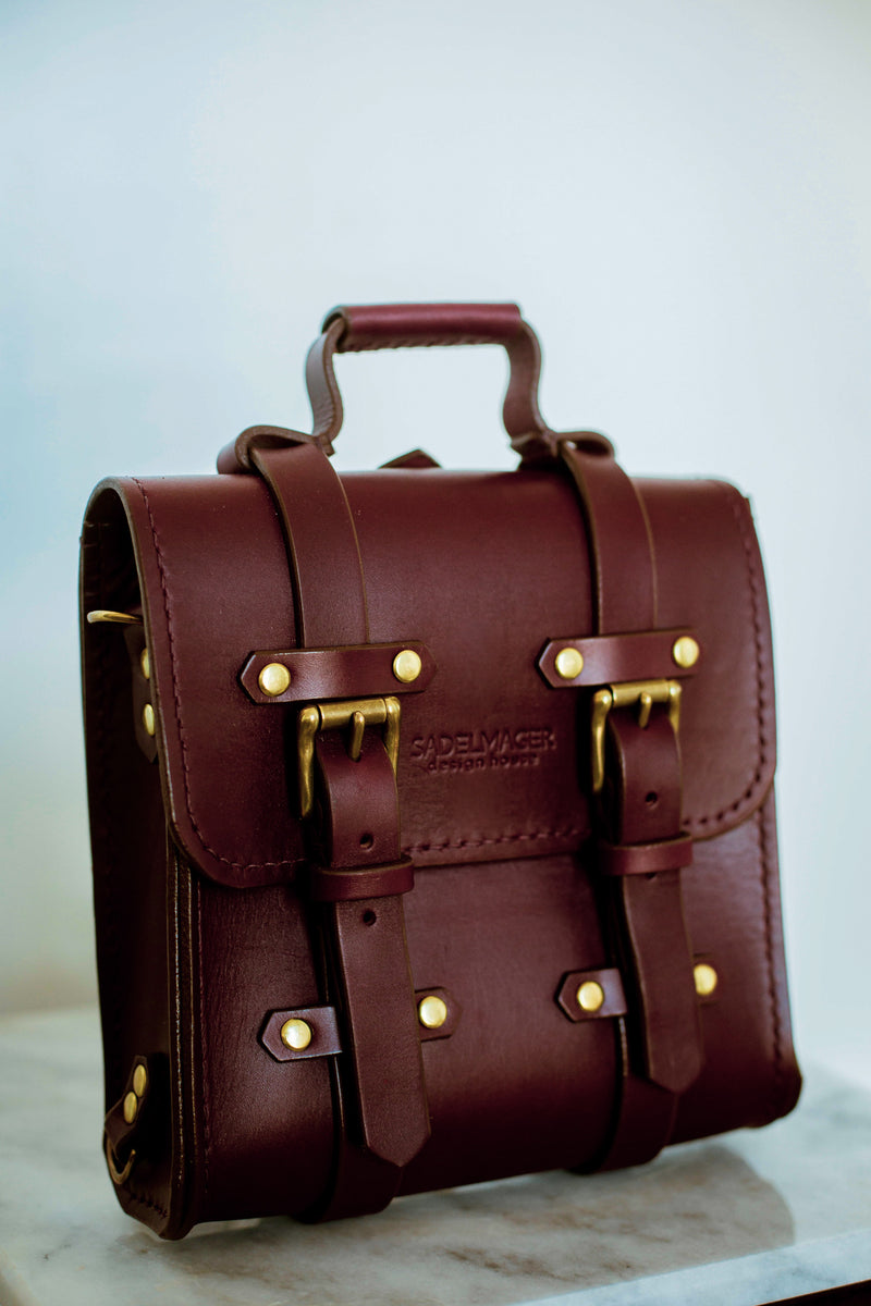 oxblood Sadelmager campus messenger with brass buckles displayed